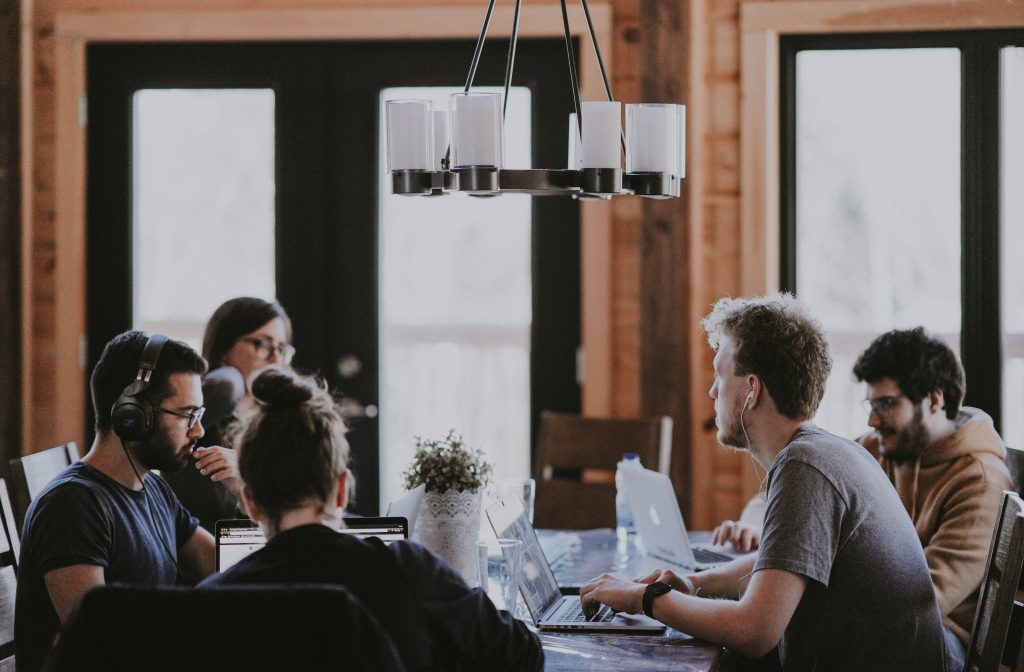 Five people sitting around a table having a meeting